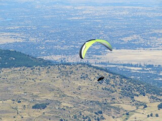 Active man paragliding above the Pena Negra town in Piedrahita, Spain