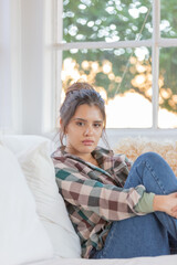 brunette girl with white teas sitting in an armchair