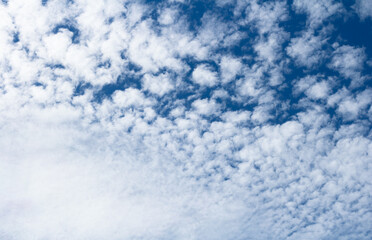 White cumulus clouds against blue sky. Atmospheric phenomena.	