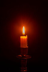 white burning candle on a black background