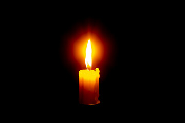 white burning candle on a black background