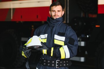 Photo of fireman with gas mask and helmet near fire engine