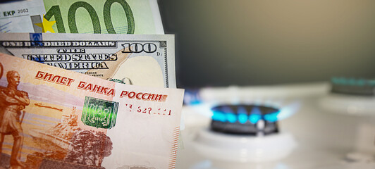 Banknotes on the background of burning gas.The concept of gas and oil payment in Russian currency.Gas crisis concept