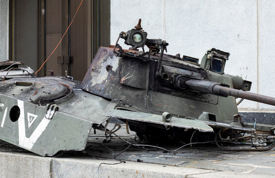 War in Ukraine. Destroyed tank with a torn off turret with a V on it. Broken and burned Russian tanks. Designation sign or symbol in white paint on the tank. Destroyed military equipment.
