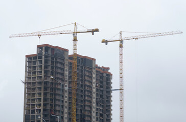 Crane tower at the construction site of a multi-storey residential building.