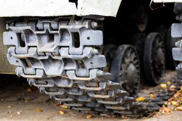 Fototapeta na wymiar Caterpillar and rollers of a green battle tank. Military army concept. Close-up camera movements. Caterpillar wheels. Tank up close.