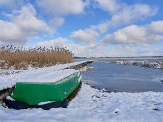 Boats on a frozen lake. Calm winter afternoon on a frozen lake