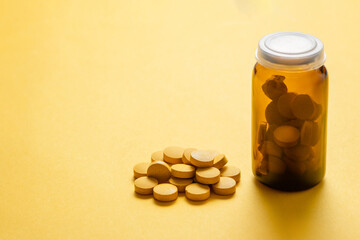 yellow round pills on a yellow background, medicine bottle, free space for text,