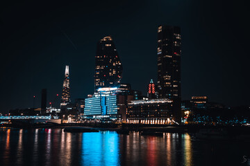 Obraz premium Illuminated building in London at night with the reflected river in the foreground