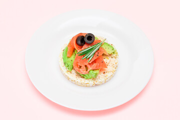 Rice Cake Sandwich with Fresh Salmon, Avocado and Olives on White Plate. Easy Breakfast. Diet Food. Quick and Healthy Sandwiches. Crispbread with Tasty Filling. Healthy Dietary Snack