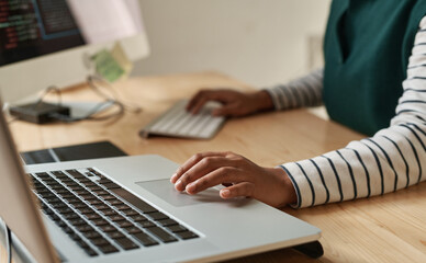 Hand of young black woman over laptop touchpad during network or creation of new website while...