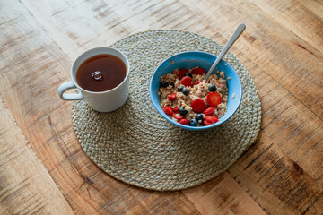 cup of tea and oats with strawberry and blueberry