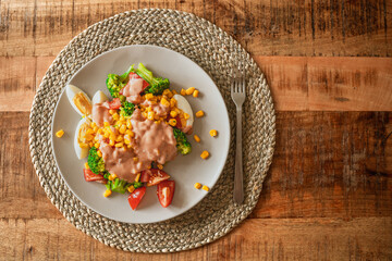 eggs with sweet corn, broccoli, tomatoes and may sauce on plate