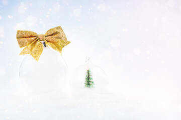 Baner poster for New Year's composition. Christmas ball for the tree.Christmas composition from a transparent ball with a gold bow on a light background with snow and bokeh.