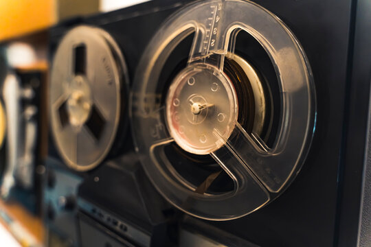 Authentic beginnings of technology. Reel-to-reel audio tape recording concept. Old vintage black recorder and player. Closeup shot. High quality photo