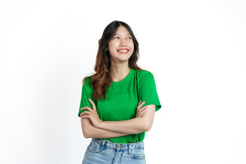 Beautiful confident Asian woman in green empty t-shirt isolated on white background. Raise your arms and look up to your left. Empty space.