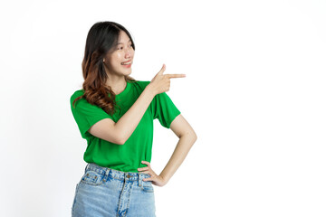 Beautiful confident Asian woman in green empty t-shirt isolated on white background. Point your finger to copy space to introduce products or services