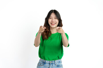 Obraz na płótnie Canvas Beautiful confident Asian woman in green empty t-shirt isolated on white background. Point your finger to copy space to introduce products or services