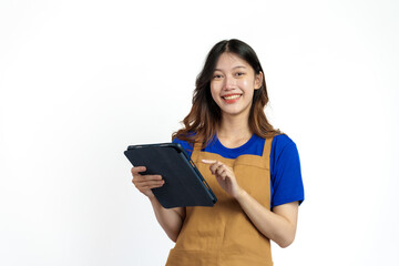 Using tablet, Cheerful young pretty asian woman blue t-shirt and apron coffee owner isolated on white background. checking order online