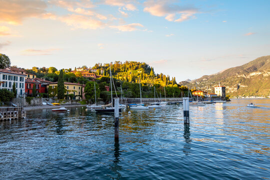 Boats are docked and moored at the peaceful fishing village of Pescallo, Italy, near the town of Bellagio on Lake Como in Northern Italy at sunset.	