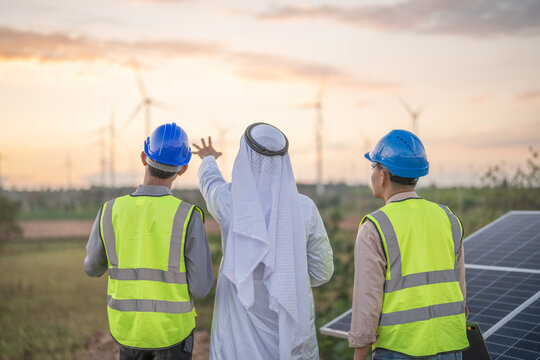 Arab Busines And Engineer Man Inspects Construction Of Solar Cell Panel Or Photovoltaic Cell By Electronic Device. Industrial Renewable Energy Of Green Power.