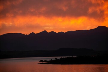 Golden cloudy sunset over the silhouettes of hills