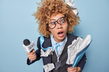 Shocked amazed female journalist keeps mouth opened works in dangerous place prepares daily news...