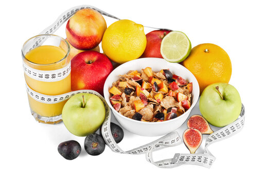 Diet weight loss breakfast concept with tape measure organic green apple, cereal bowl, orange juice, pineapple, muesli cereal bowl, pear, kiwi, lemon, strawberries on a white background