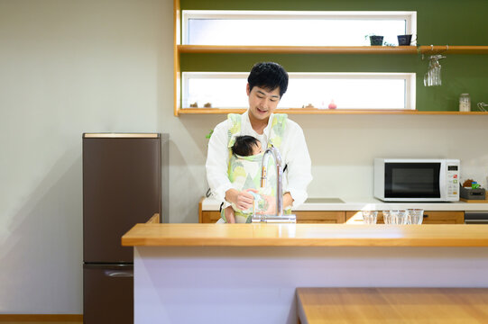 Dad Doing One-operation Housework While Carrying A Baby Copy Space Available Wide Angle