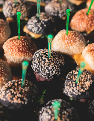 Obraz premium Burger mini burgers snacks on a wooden table with craft paper, beautifully decorated catering banquet table on a corporate christmas birthday party event or wedding celebration