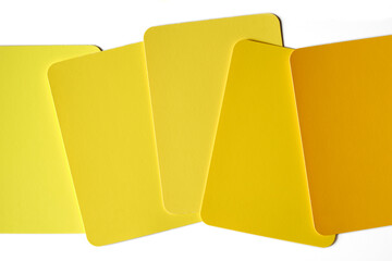 Generic color swatches scattered on a table. Various shades of yellow, from light to dark, left to...