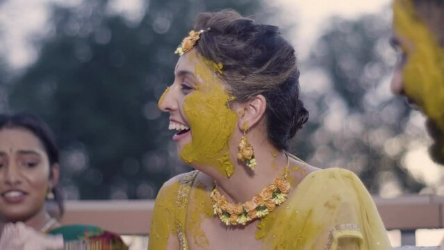 Family And Friends Applying Turmeric To The Bride And Groom In An Indian Wedding - closeup