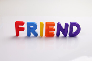 red green blue yellow plastic toy capital font letter alphabet friend on white background copy text space concept