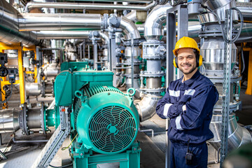 Portrait of smiling caucasian blue collar worker standing by gas fuel engines inside power plant.