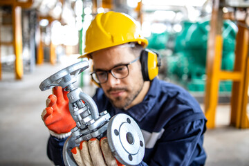 Oil and gas refinery worker checking industrial high pressure valve before installing on gas pipes.