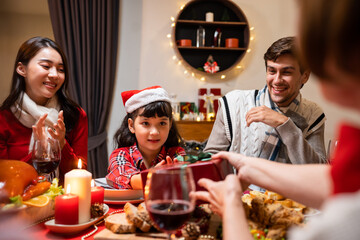 Multi-ethnic family exchanging presents during Christmas party at home.