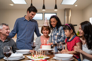 Multi-ethnic big family having birthday party for senior grandmother.