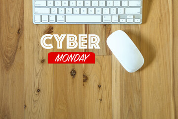 Cyber Monday message, with keyboard and computer mouse on wood table. Top view.