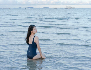 Fototapeta na wymiar woman kneels in shallow seawater