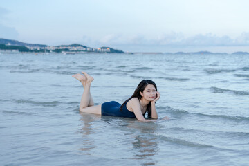 young woman lying on Seashore in Water
