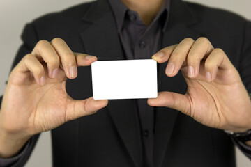 Obraz premium A man's hand holding white card for inter card concept design, and smart dart man showing white mock up ID card on white background.