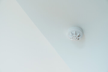 Smoke sensor detector mounted on roof in home or apartment. Safety and conflagration security concept