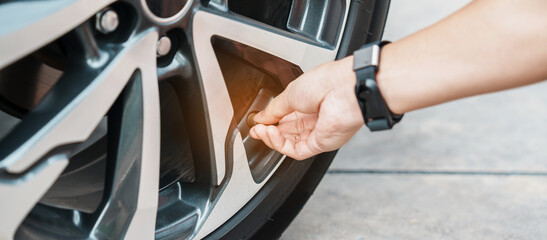 driver hand inflating tires of vehicle, removing tire valve nitrogen cap for checking air pressure and filling air on car wheel at gas station. self service, maintenance and safety © Jo Panuwat D