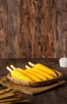Group of corn cob in tray on wood tabele and wall
