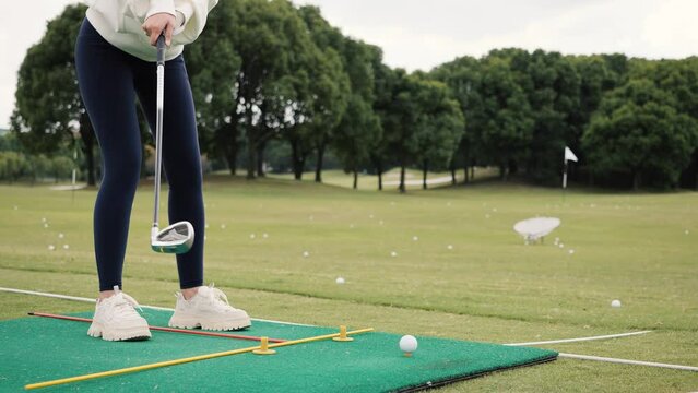 Female beginner practice golf, successfully hit the ball, 4k slow motion footage.