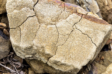 a piece of sandstone cracked under the influence of atmospheric phenomena, selective focus