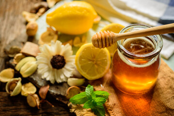 Honey with fresh lemon on wooden table background,  honey dipper