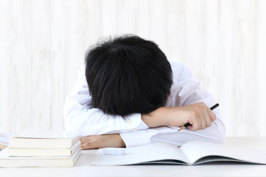 机に頭を伏せる子供―勉強をしたくないイメージ