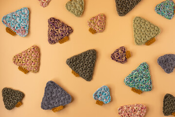 Handmade crochet christmas tree on orange pastel background. Merry Christmas and happy new year concept.