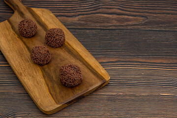 brazilian brigadeiro traditional delicious chocolate dessert, party snacks, sweet sprinkle background top view over wooden table